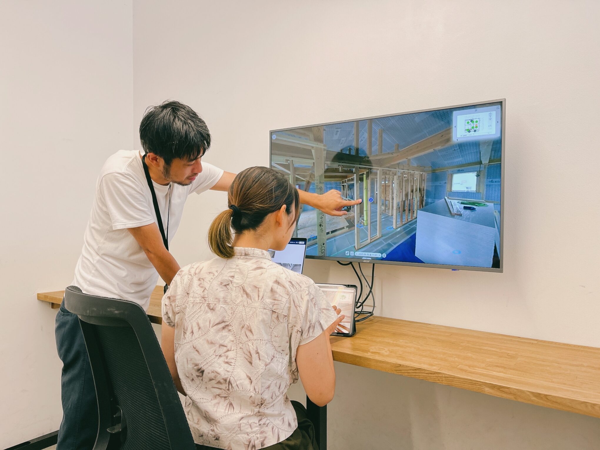 設計と現場管理のスタッフが画面を見ながら確認している様子
